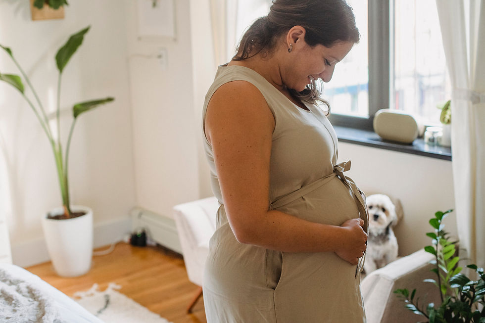 Une femme enceinte dans une chambre lumineuse qui sourit