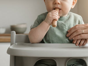 Un bébé qui teste la diversification menée par l'enfant avec un bâtonnet fondant