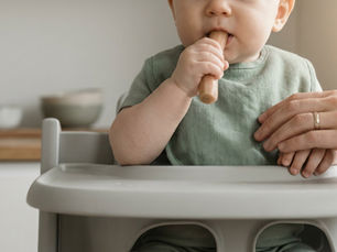 Un bébé qui teste la diversification menée par l'enfant avec un bâtonnet fondant