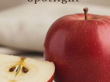 A sliced apple with an apple next to it