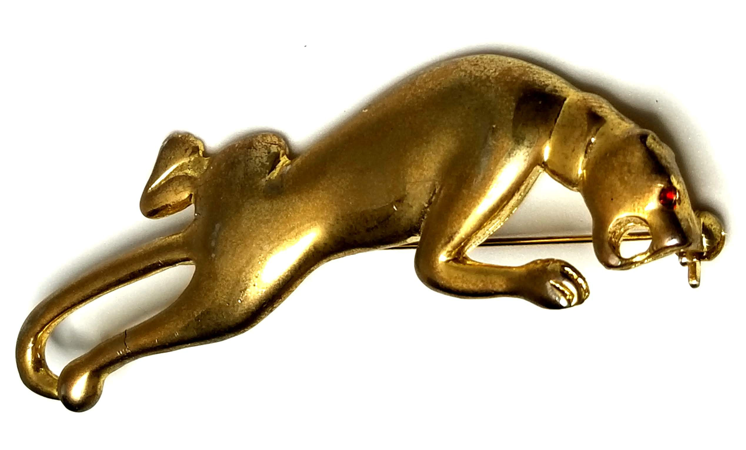 Designer by provenance, brooch, wild cat motif, red glass stone, gold tone.