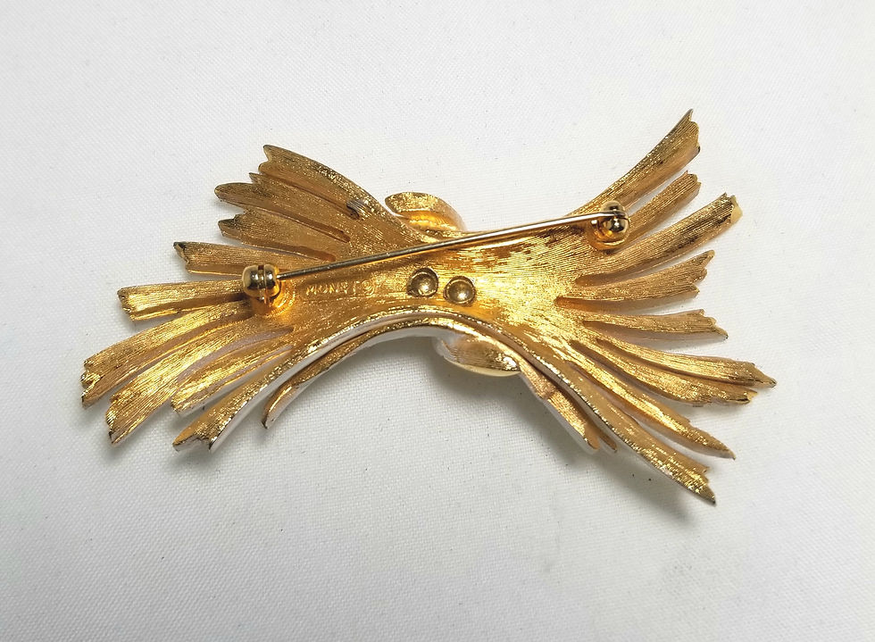 Thumbnail: Monet brooch, white enamel ribbons with gold tone base.