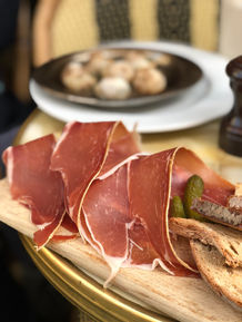 Thinly sliced prosciutto with cornichons and bread
