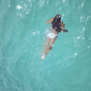 Woman in a bikini swimming in clear blue ocean water