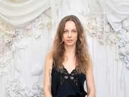 Fanni Kopácsi accanto a una delle sue opere tessili realizzate con stoffe recuperate e stratificazioni materiche