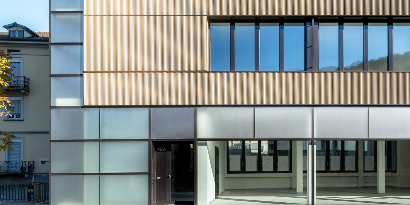 Grandi aperture in vetro e serramenti minimali Vistec SA che definiscono l'estetica e l'individualità del design urbano contemporaneo.