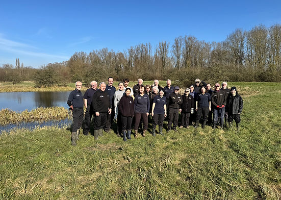 Volunteers and staff smiling in the sunshine on Cornmill Meadows Dragonfly Sanctuary