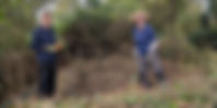 Two people clearing scrub 