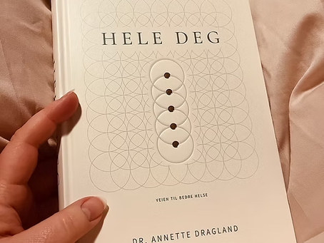 Boken ‘Hele Deg’ av Annette Dragland ligger i fanget mitt mens jeg holder hånden på omslaget.