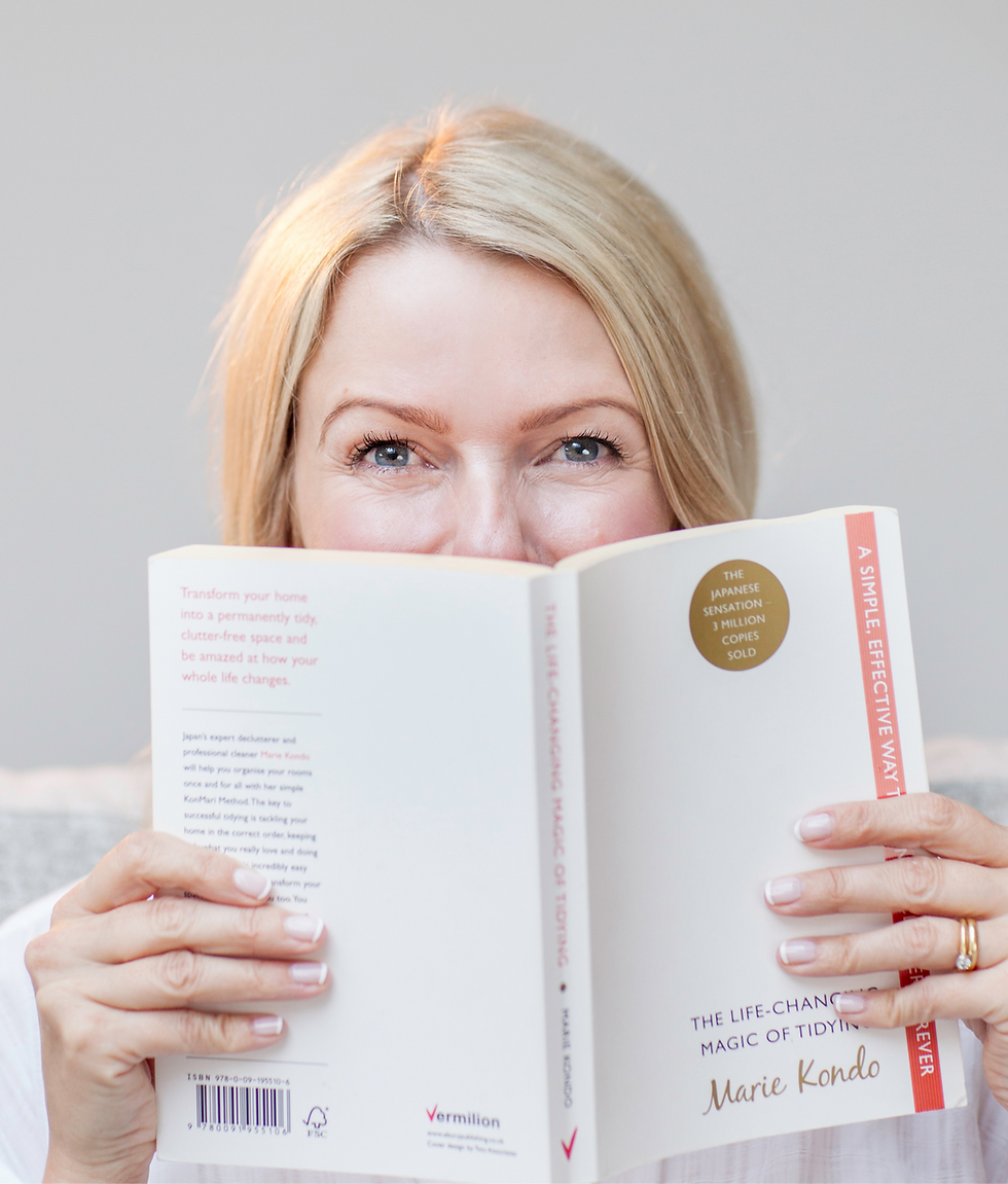 Lynn Kirk, life coach and founder of Happily Sorted, smiling while holding Marie Kondo's The Life-Changing Magic of Tidying Up