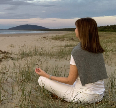 Jane Otton, founder of Calm Mind College, meditating on a beach