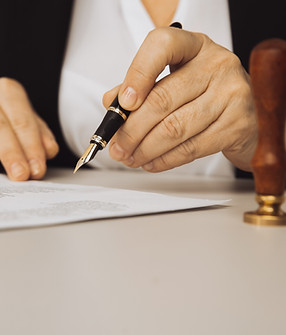 closeup-view-female-hand-holding-pen-paper-stamp-desk.jpg