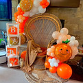 orange balloon garland and peacock chair