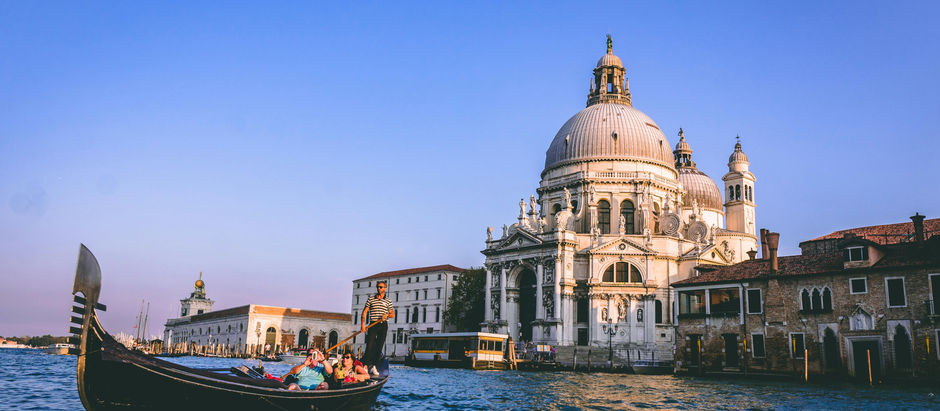Italy, people sitting in a boat with a beautiful view of the sunset and a cathedral in italy