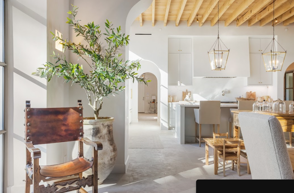Interior kitchen and dining area with sunlight streaming through large windows