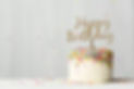 Colorful birthday cake with golden happy birthday banner and falling sprinkles.jpg