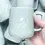 Thumbnail: Hand holding Sunrise Coffee mug next to a beige "Good Morning Sunshine" mug