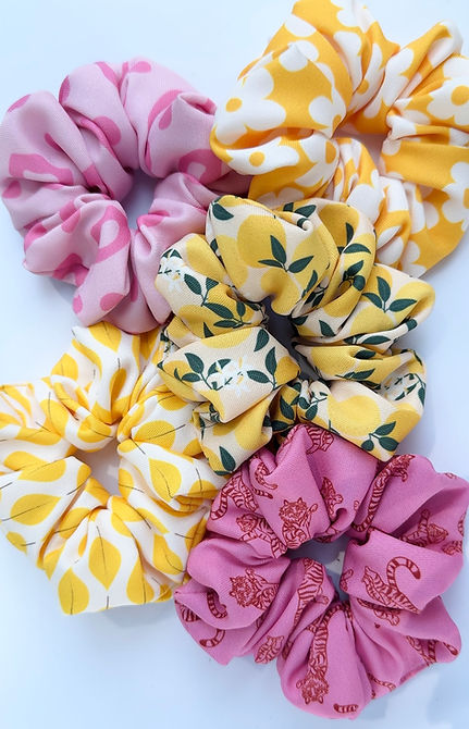 Kolorowe scrunchie dla kobiet w różnych rozmiarach oraz wzorach.