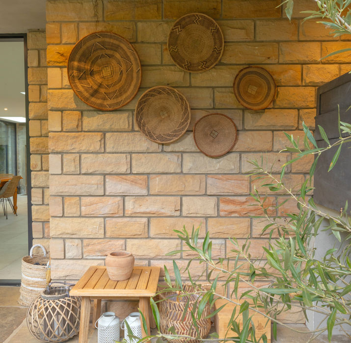 Woven basketware accessories against an outdoor wall designed by Khaya Interiors