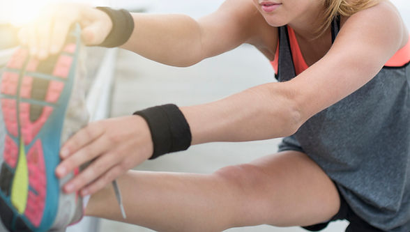 woman stretching wearing sweatband