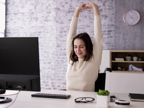 Woman feeling refreshed and relaxed at her desk