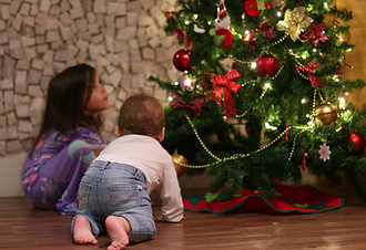 children-next-to-christmas-tree-during-holiday-season-little-girl-and-infant-boy-SBI-35119