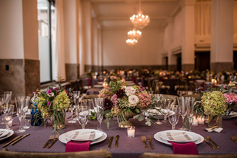 Purple, sage green, and gold themed table settings with gorgeous white, pink, and purple flowers