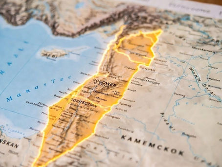 Close-up of a map with highlighted regions in orange and text detailing geographical areas. Blue sea and land features visible.