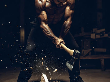 Muscular man chopping wooden letters spelling "EGO" with an axe, amidst flying wood chips, in a dimly lit workshop setting.