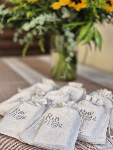 שקיות בד ריי אוף לייט על שולחן עם פרחים ברקע, יפה.