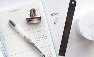 Organized Desk Supplies: A pen, a planner, safety pins, and a ruler
