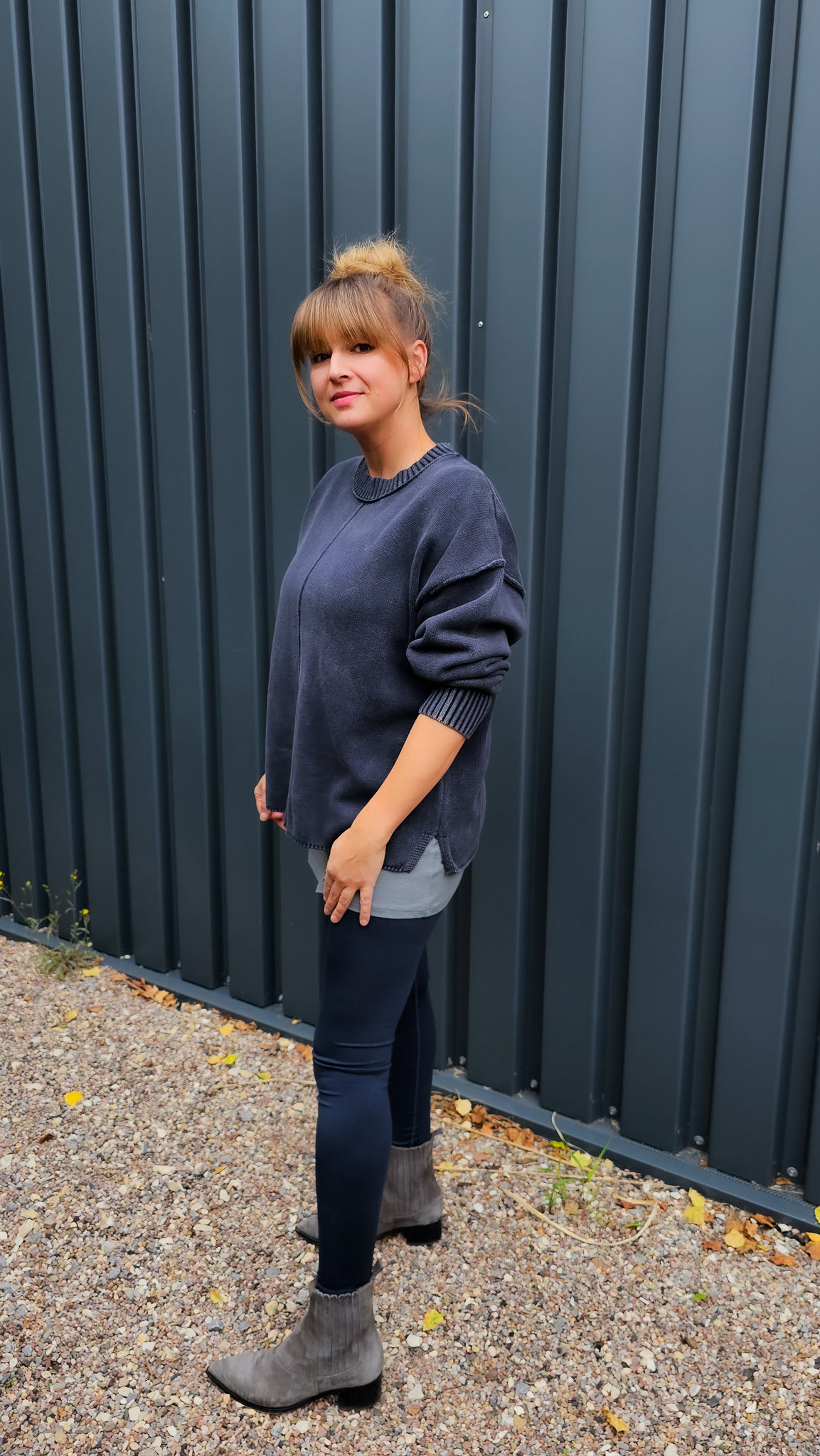 Model trägt gewaschenen Baumwollpullover in After Midnight Wash mit Ziernaht und langem Top darunter.