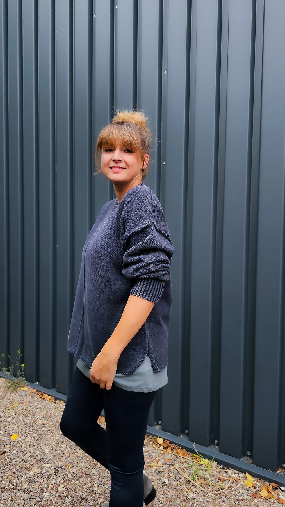 Miniaturbild: Model trägt gewaschenen Baumwollpullover in After Midnight Wash mit Ziernaht und langem Top in grau darunter.