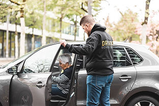 Stefan helps an elderly lady to get in her car.