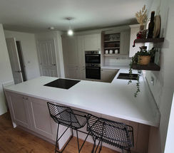 Grey modern kitchen with shaker-style doors, black handles and a marble worktop, fitted by SB Carpentry & Building