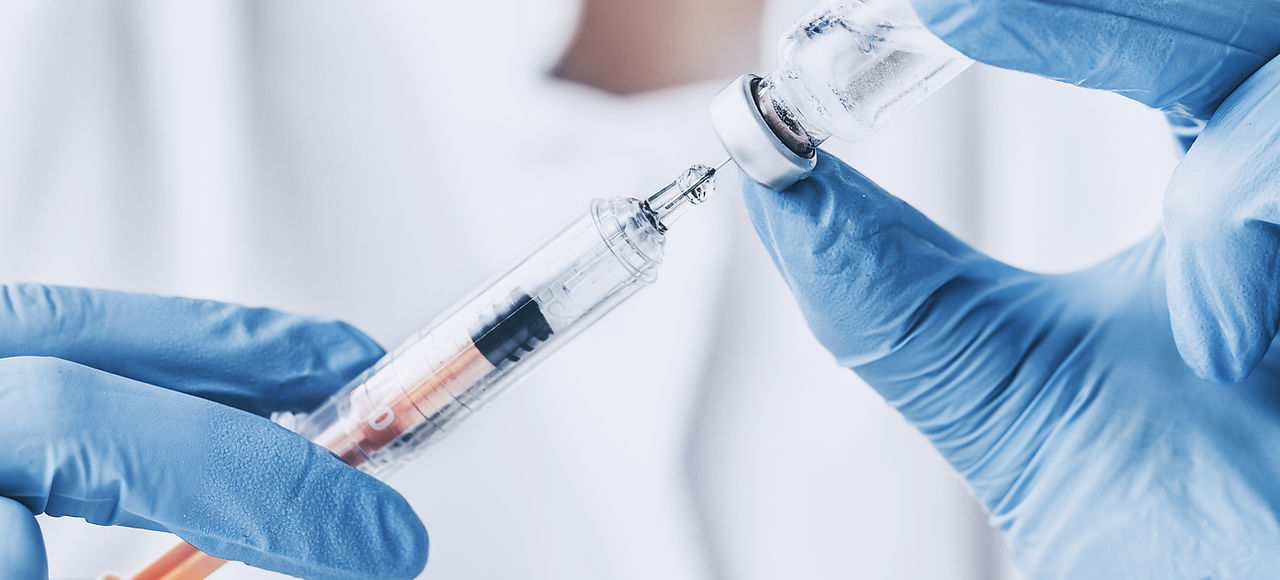 Hands preparing syringe