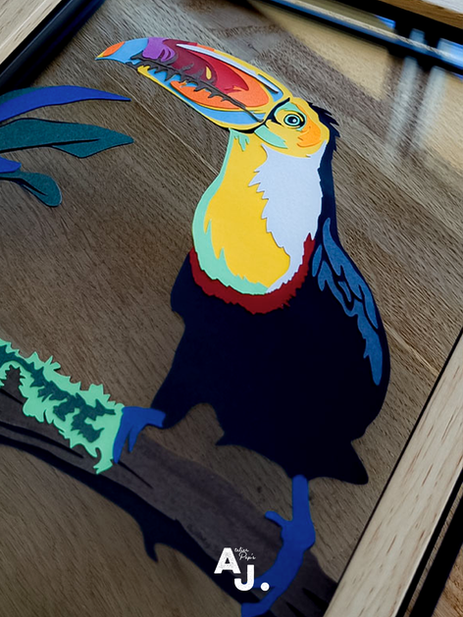 Toucan en papier découpé fait main, création artisanale inspirée des oiseaux tropicaux. Une décoration murale en papier originale et colorée.