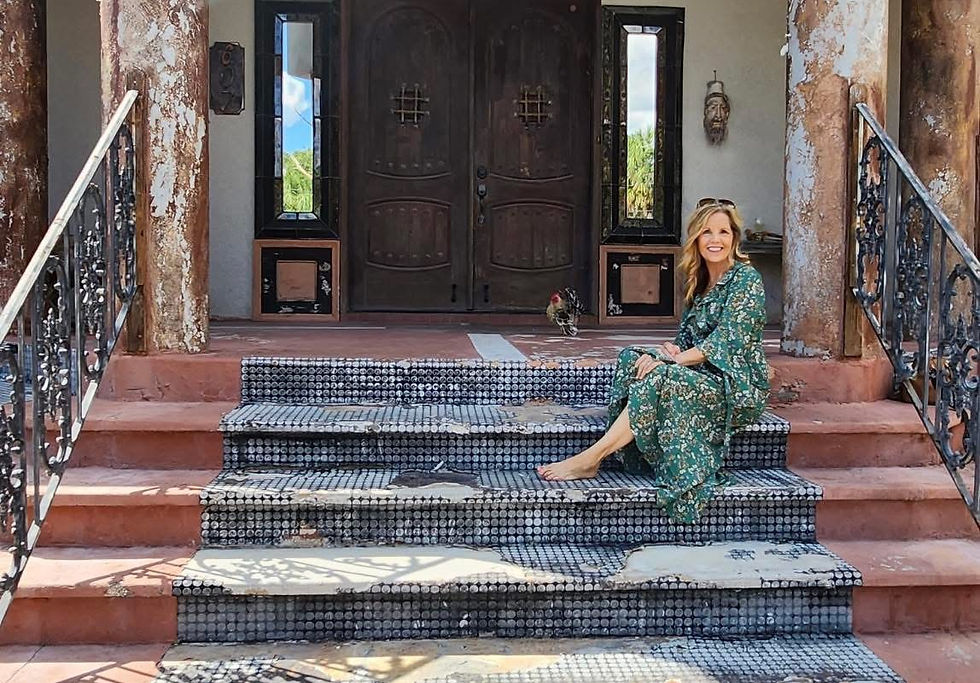 Tina K sitting on front steps of a old home 