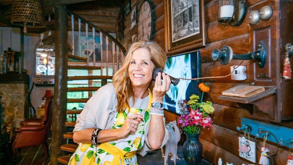 Tina K wearing an apron talking on an antique telephone