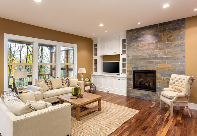 This renovation went from bland walls to a new electric fireplace with a stone tile feature. Existing cabinets were added for an entertainment section. With new hardwood floors and a warm paint color it brought this living room together.