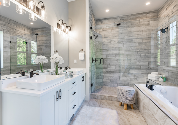 His and Hers mirror offer a striking appearance to the space and add reflections making the appearance of a larger bathroom. Stylish Tile Floor that flows up and around the jacuzzi tub makes for a seamless look. White modern vanity purchased online with independent sinks set on top.