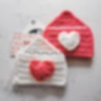 The Crochet Heart Envelope Gift Card Holder holding gift cards. The yarn colors are pink and white on a white countertop.
