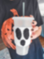 The crochet ghost cozy on a reusable iced coffee mug.