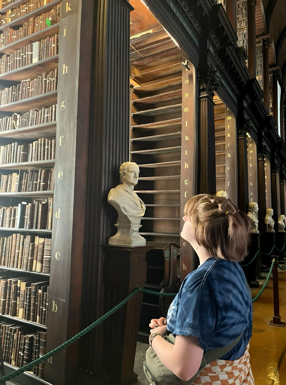 Girl in a library looking at books
