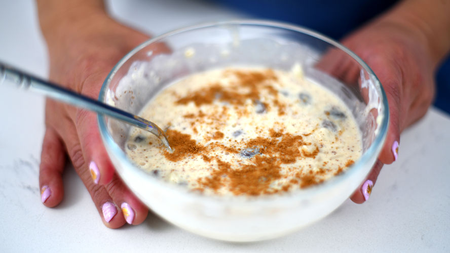 Hands holding a bowl of arroz con leche (Mexican rice pudding)
