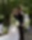 Groom kisses bride's forehead at outdoor wedding