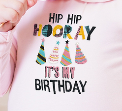 "hip hip hooray it's my birthday" on a pink sweatshirt, with four colourful party hats.