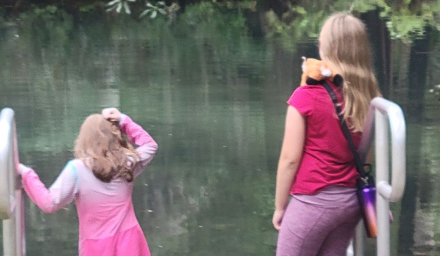 Two girls wading into Mud Spring