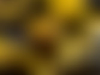 Glossy yellow and black paint dripping from metal rods, creating abstract patterns. The background is dark, enhancing the vivid colors.