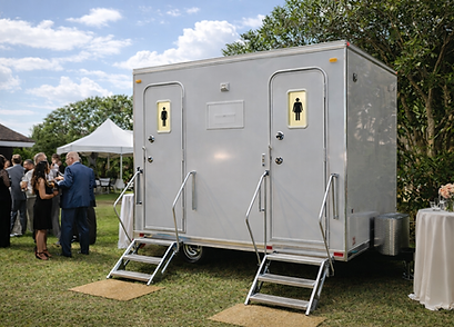 Two-stall luxury restroom trailer set up at an outdoor wedding for guests, with clean exterior access and upscale event-ready